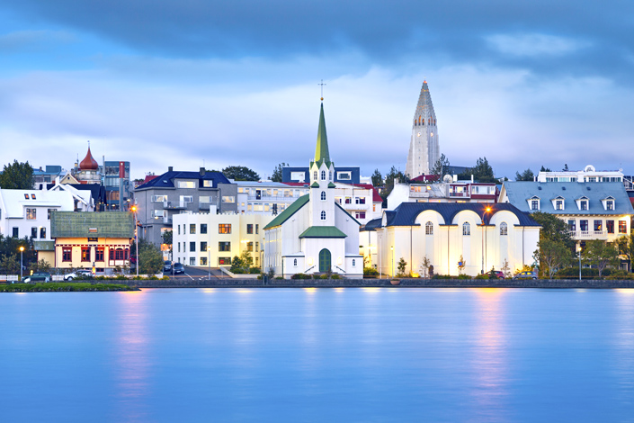 Reykjavík - pohled na tradiční dřevěný kostel na břehu zálivu, v pozadí s kostelem Hallgrímskirkja